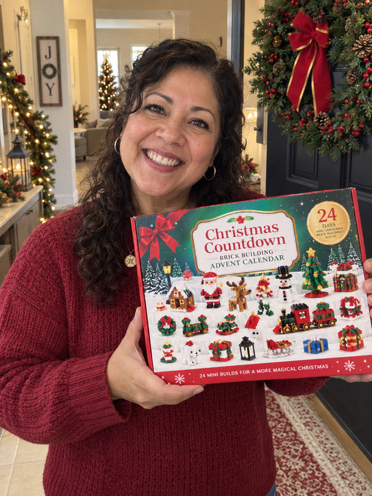 Woman in a red sweater holding the advent calendar by a Christmas wreath.